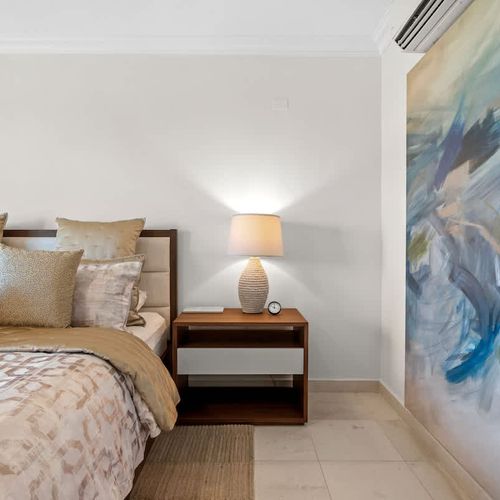 Luxurious and inviting bedroom, adorned with soft linens and plush pillows. The room exudes tranquility with its neutral color palette and modern design elements.