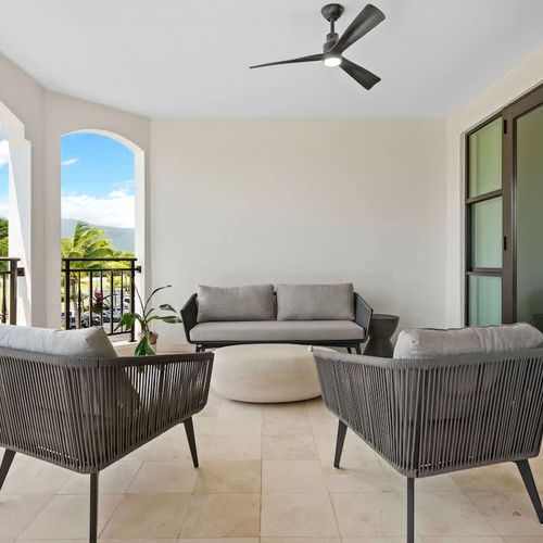This cozy balcony is ideal for relaxing, with comfy seating, a stylish coffee table, and a ceiling fan. Enjoy stunning views of the tropical landscape and ocean while sipping your favorite drink and soaking up the sun.