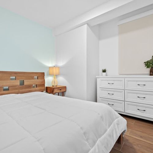 Bright and airy bedroom with comfortable bed and ambient lighting.