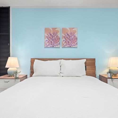Plush queen bed, stylish nightstands & captivating art. Your serene sleep sanctuary.