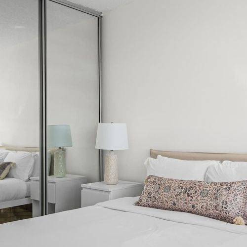 Unwind in comfort and style. The elegant headboard and thoughtful lighting create a sophisticated ambiance in this tranquil bedroom, perfect for a peaceful escape