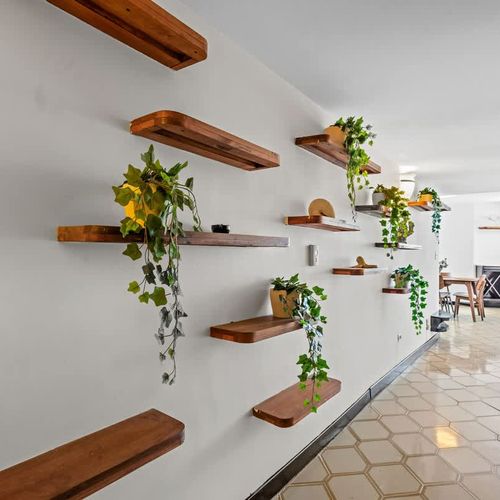 A warm welcome awaits! The inviting hallway, adorned with charming floating shelves and lush greenery, sets a delightful tone for your stay from the moment you arrive.
