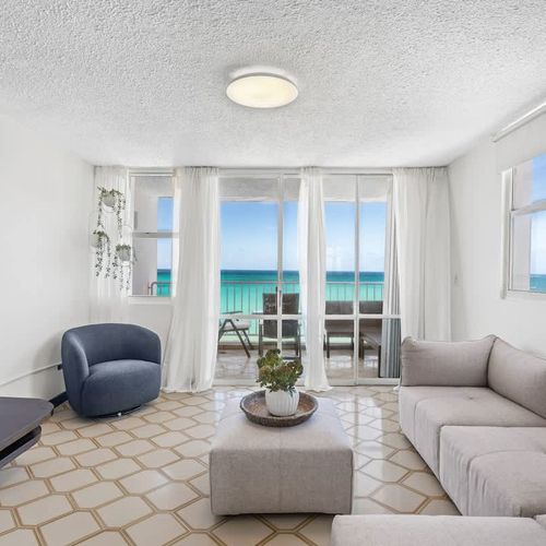 Relax in style! This beautifully appointed living room offers plush seating and direct access to your private balcony, providing an idyllic setting for enjoying the ocean breeze and views.