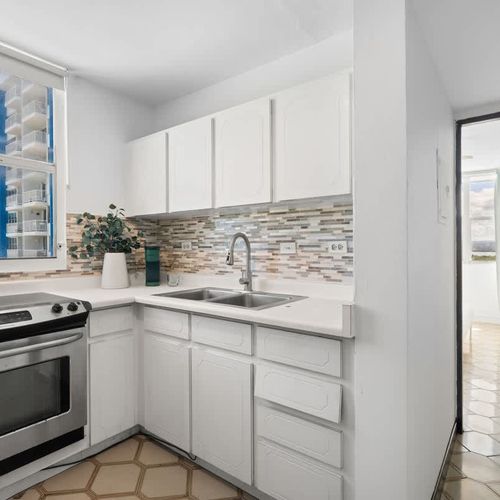 Enjoy the convenience of home cooking while on vacation! This bright kitchen offers a modern stove, microwave, and plenty of storage, making meal prep a breeze.