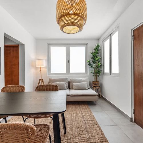 Relax and entertain in this open area, featuring a comfortable sofa, a dining table, and a flat-screen TV for your convenience.