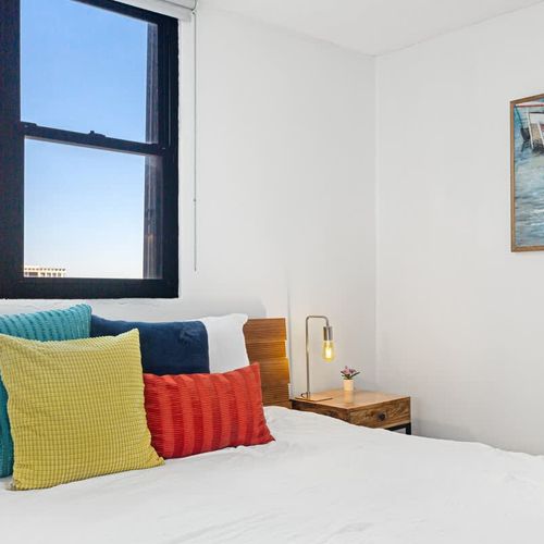 Peaceful bedroom with vibrant touches and natural light.