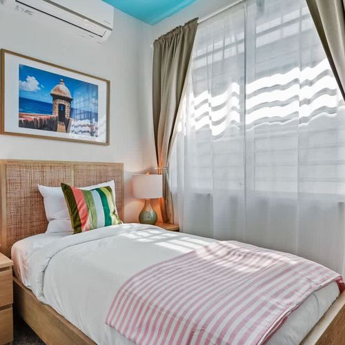 Unwind in this stylish bedroom with a cozy bed and unique rattan headboard.