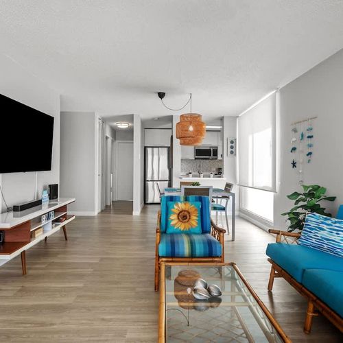 Spacious and inviting! This vibrant living room offers comfortable seating, a large flat-screen TV, and ample natural light, creating the perfect hub for relaxation and entertainment.