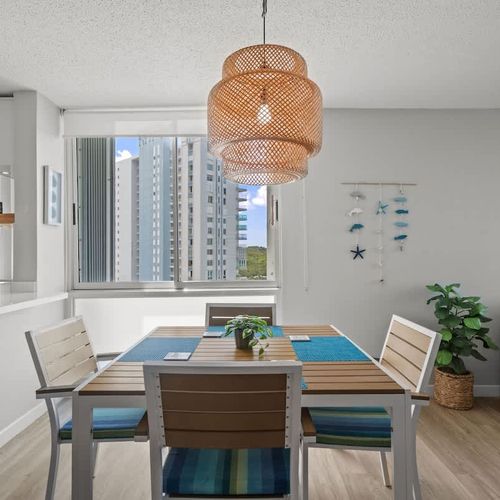 "Al fresco dining made easy! This elegant dining area, perfectly positioned next to the balcony, allows you to enjoy meals with a refreshing breeze and lovely outdoor views.