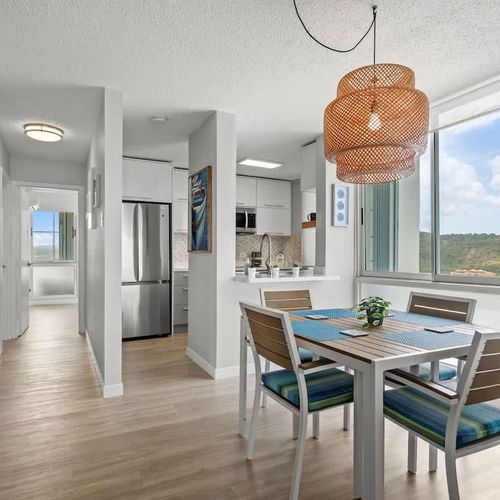 Chef's delight in a bright setting! This modern kitchen and dining area boasts sleek countertops, ample space for cooking, and a comfortable dining table, perfect for culinary adventures and shared meals.