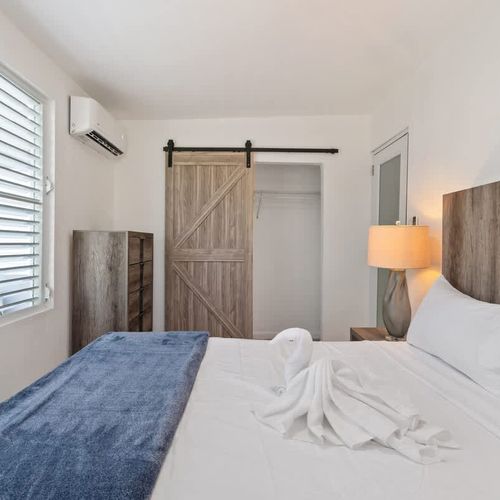 A peaceful chamber with a large bed and a rustic sliding panel.