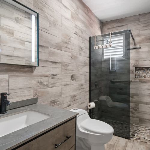 A spa-like bathroom with stunning wood-like tiles throughout the space.