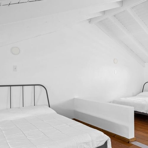 This spacious room features clean lines and ample natural light, creating a serene and inviting space. Perfect for relaxation and rest.