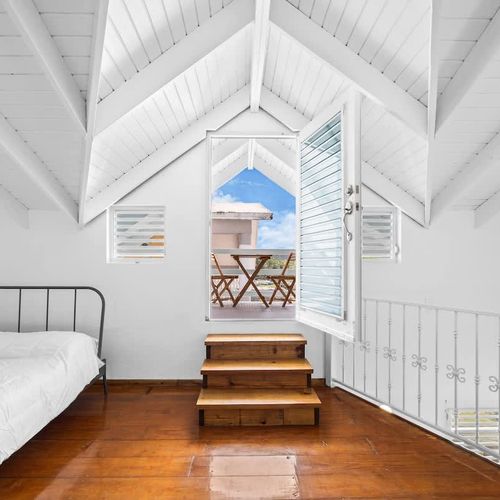 bedroom with private balcony, bed, soft linens and pillows