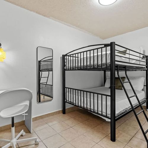 Sleek black bunk beds in a bright room offer a cozy corner for relaxation.
