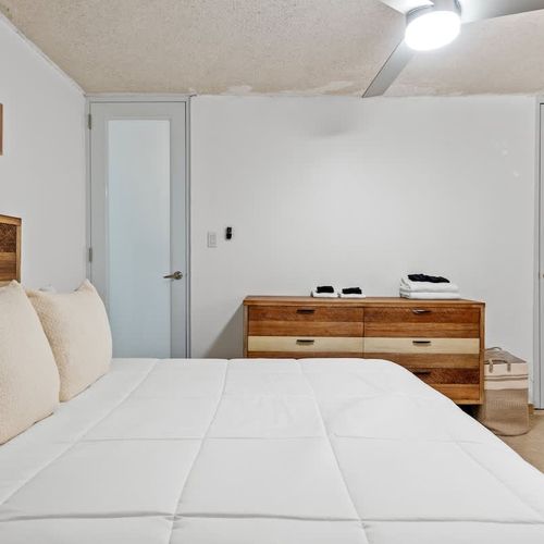 Relax in this inviting bedroom that combines modern comfort with a touch of rustic charm, highlighted by a spacious wardrobe and contemporary decor.