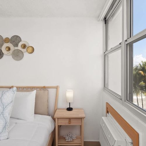 room with beachfront beach views, bed and wall art