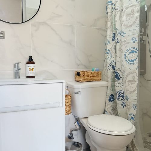 Bright and clean bathroom with modern finishes, marble-style tiles, rainfall shower, and thoughtful details. Enjoy a refreshing and comfortable stay at Luna Suite, Casa Natura.