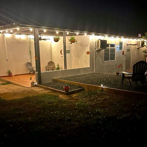 Charming night view of Luna Suite at Casa Natura, featuring warm patio lights, a cozy terrace, and peaceful outdoor seating. Perfect for unwinding under the stars in a serene, nature-filled setting.