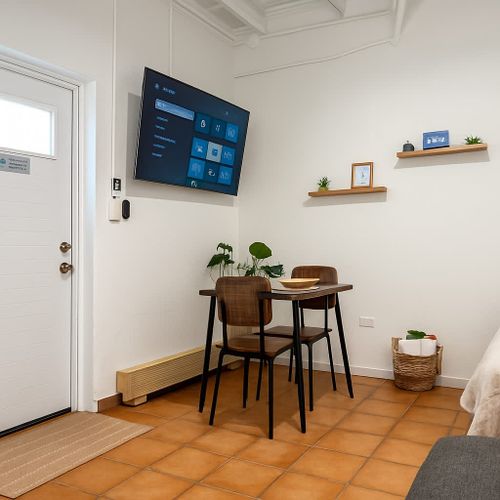 Modern dining nook with Smart TV, natural light, and minimalist decor. Enjoy a cozy meal or movie night in this clean, stylish corner of Luna Suite at Casa Natura.