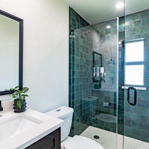 This bright and sleek bathroom offers a large, walk-in shower to refresh after a great night's sleep.