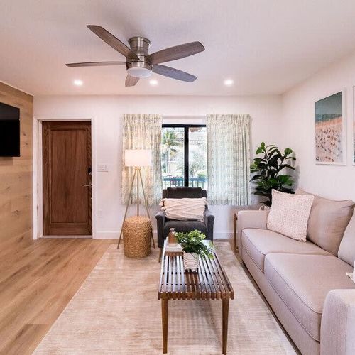 The living room is meant to help you relax and get out of the sun, complete with a ceiling fan, wide couch, and Smart TV.