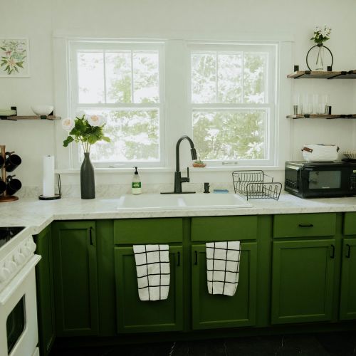 Experience the elegance of our white and green kitchen design, complete with all essential kitchen amenities.