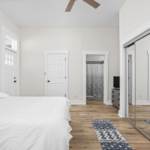 Step into our primary bedroom, featuring a plush queen bed, two accent chairs for relaxing, ample storage, and a TV!