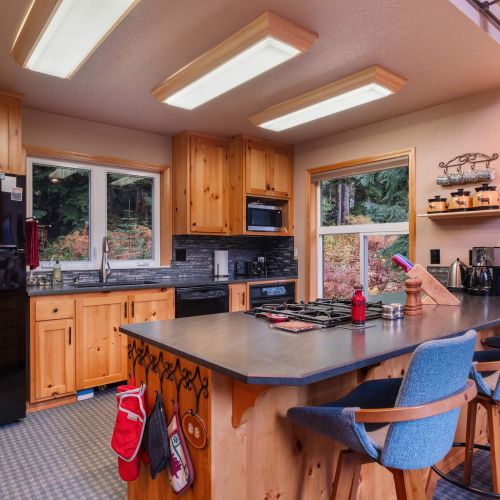 A spacious kitchen with a functional kitchen bar provides extra seating and space to enjoy meals or chat while cooking.