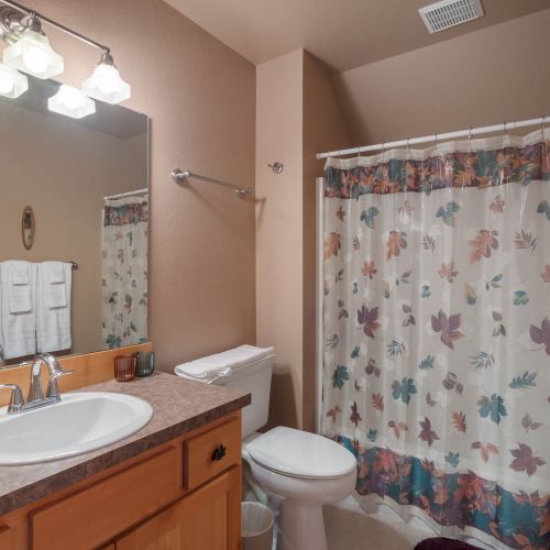 A cozy bathroom with a wooden sink vanity and natural accents, offering a calming, earthy vibe to complement modern amenities.