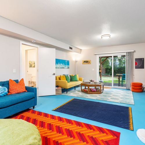 Step into our dynamic room, where vibrant carpets and a plush sofa bring color and comfort together!