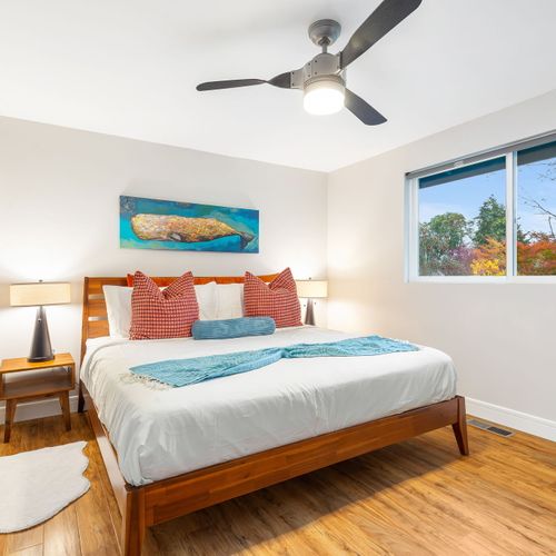 This serene bedroom exudes calm vibes, featuring soft decor and a stylish table for added functionality.