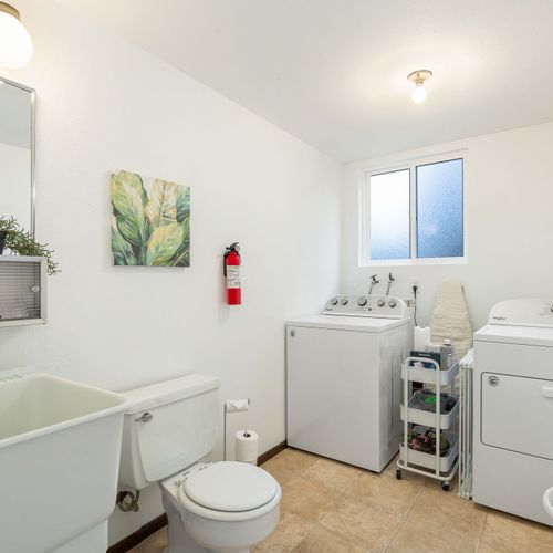 A spacious bathroom with a discreet laundry area, designed to make household chores easy and accessible.