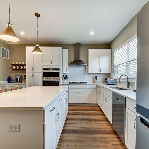 This modern kitchen boasts stainless steel appliances, elegant pendant lighting, and bar seating, offering both style and comfort for a luxurious stay!