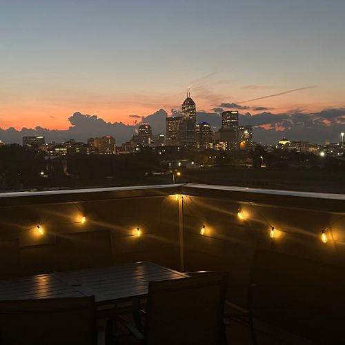 The rooftop deck offers comfortable furniture, a dining table for six, and stunning city skyline views—perfect for relaxing or enjoying a meal with a view.