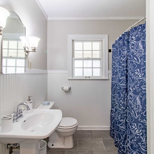 A bright and clean full bathroom featuring a modern sink, a sleek toilet, and a shower-tub combo perfect for relaxing soaks or refreshing showers. Stocked with fresh towels, toiletries, and all the essentials for a comfortable stay.