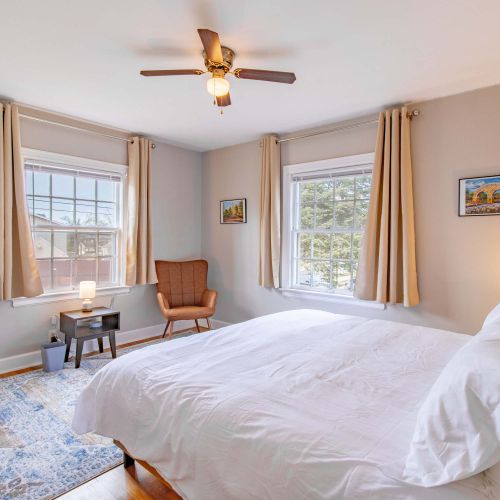 This king bedroom boasts a comfortable bed, a stylish accent chair, and charming decorative touches, creating a relaxing and inviting atmosphere.