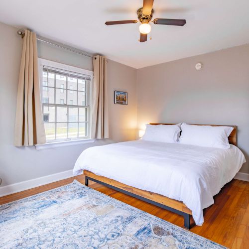 This king bedroom boasts a comfortable bed, a stylish accent chair, and charming decorative touches, creating a relaxing and inviting atmosphere.