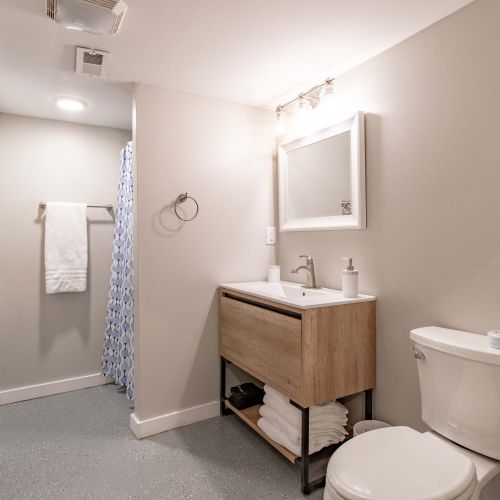 A bright and clean full bathroom featuring a modern sink, a sleek toilet, and a shower-tub combo perfect for refreshing showers.