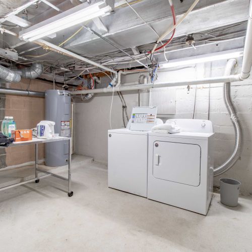 This laundry space features a separate washer and dryer with ample laundry supplies.