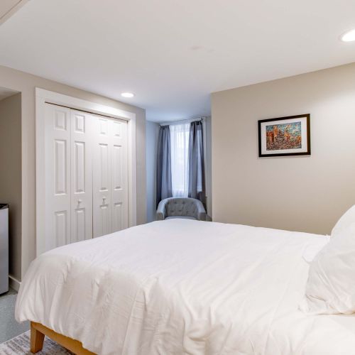 Relax and unwind in this bedroom features a queen bed, accent chair, and a mini fridge for your convenience!