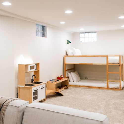Children's play area and twin over twin bunk bed in basement