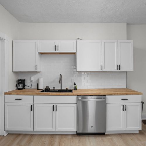 Kitchen: Sleek white cabinetry and butcher block counters make cooking a delight! Enjoy modern amenities!