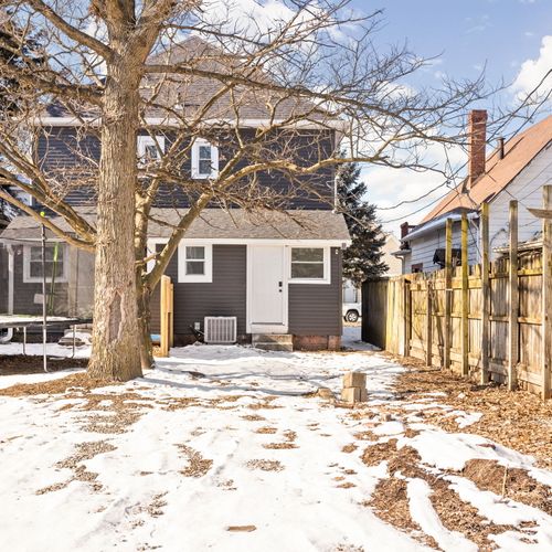 Backyard featuring a parking pad and walkway to the front door.