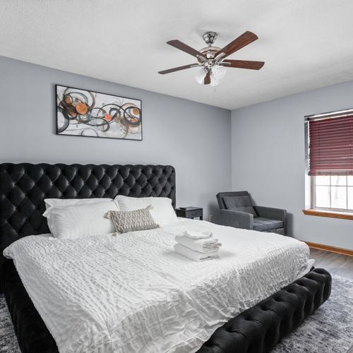 Step into the master bedroom! Featuring a king bed, two nightstands, and a lounge chair that can be pulled out into a sleeping space.