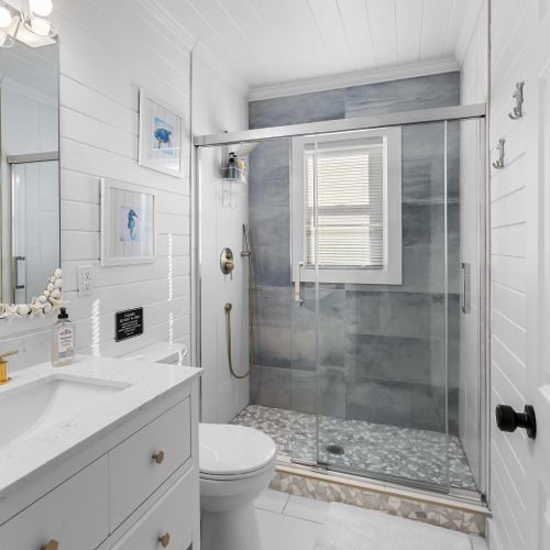 Mid century modern bathroom with natural light, terrazzo floors and marble on the walls and shower.