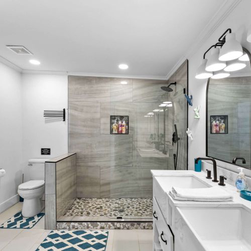 Mid century modern bathroom with natural light, terrazzo floors and marble on the walls and shower.