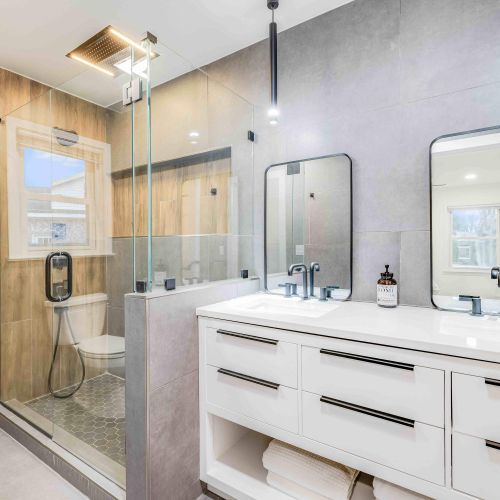 Experience spa-like luxury in Bathroom 1, featuring a sleek double vanity, a rainfall shower, and elegant finishes—perfect for unwinding after a day of exploring.