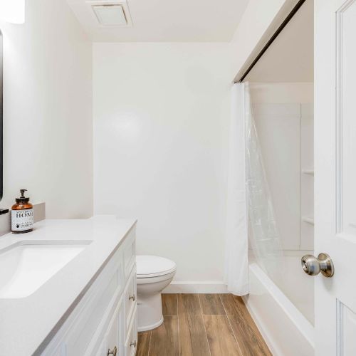 Bright and modern! This elegant bathroom features a sleek vanity with stylish black fixtures, perfect for a refreshing and comfortable stay.