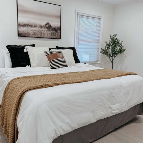 Spacious and inviting Bedroom 1 featuring a plush bed, warm accents, and a serene atmosphere.